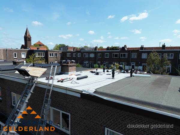 Dakdekkers aan het werk op plat dak in Gelderland