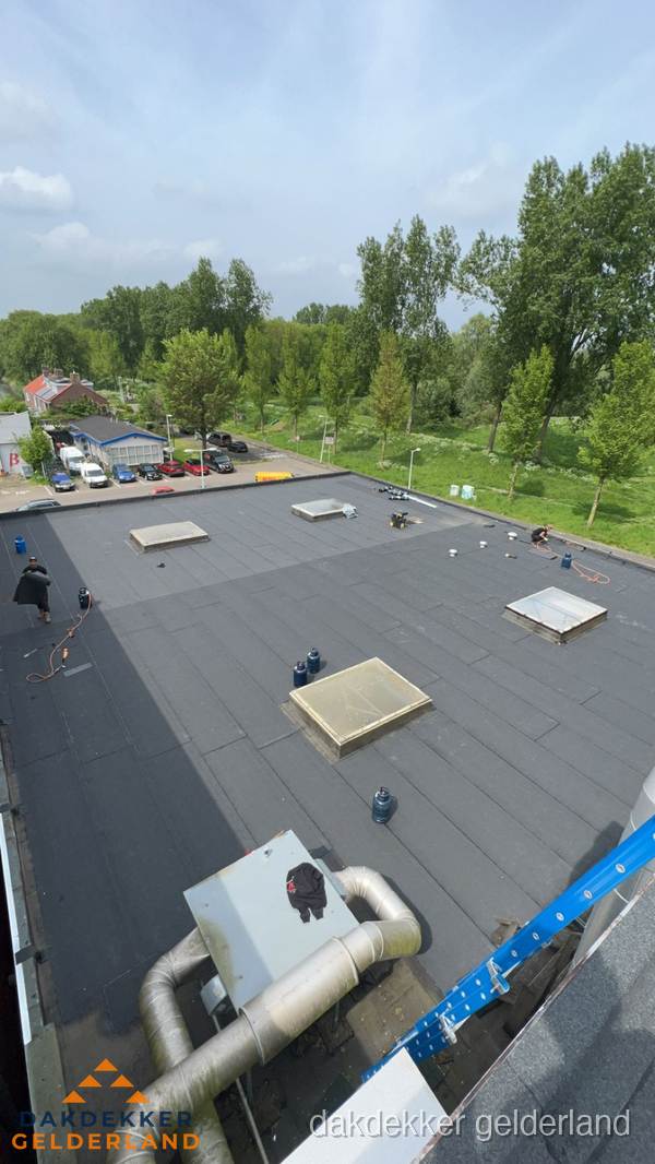 Dakdekker aan het werk op groot plat dak met bitumen in Gelderland Dakdekker aan het werk op groot plat dak met bitumen in Gelderland